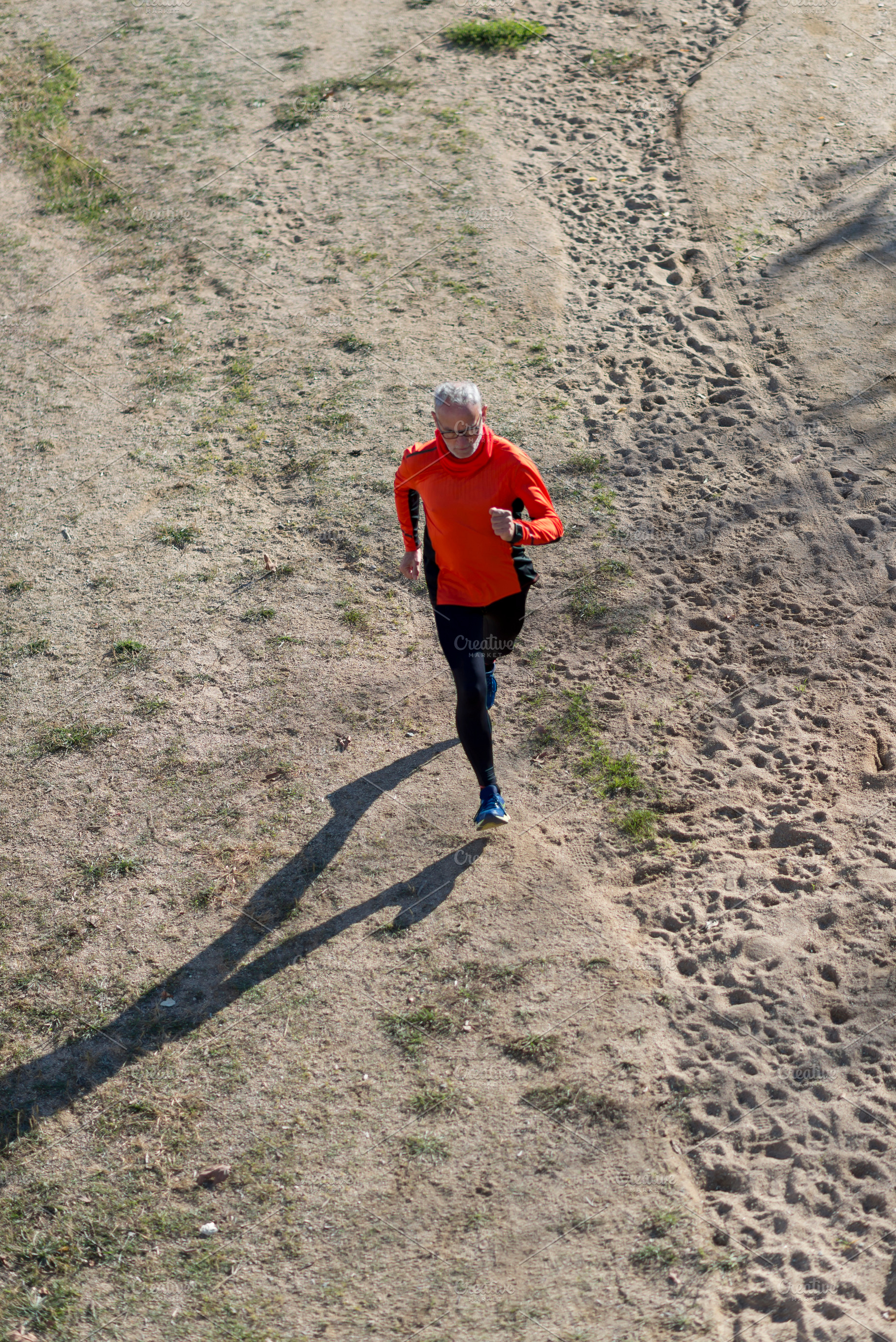 Senior man running on dirt trail from aerial perspective, a Sports & Recreation Photo by RF Images