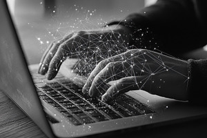 Hands typing on a laptop with digita, a Photo by Tanuart