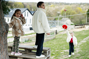 Three children playing outdoors in the countryside wearing warm coats and sneak, a Person Photo by AS photostudio