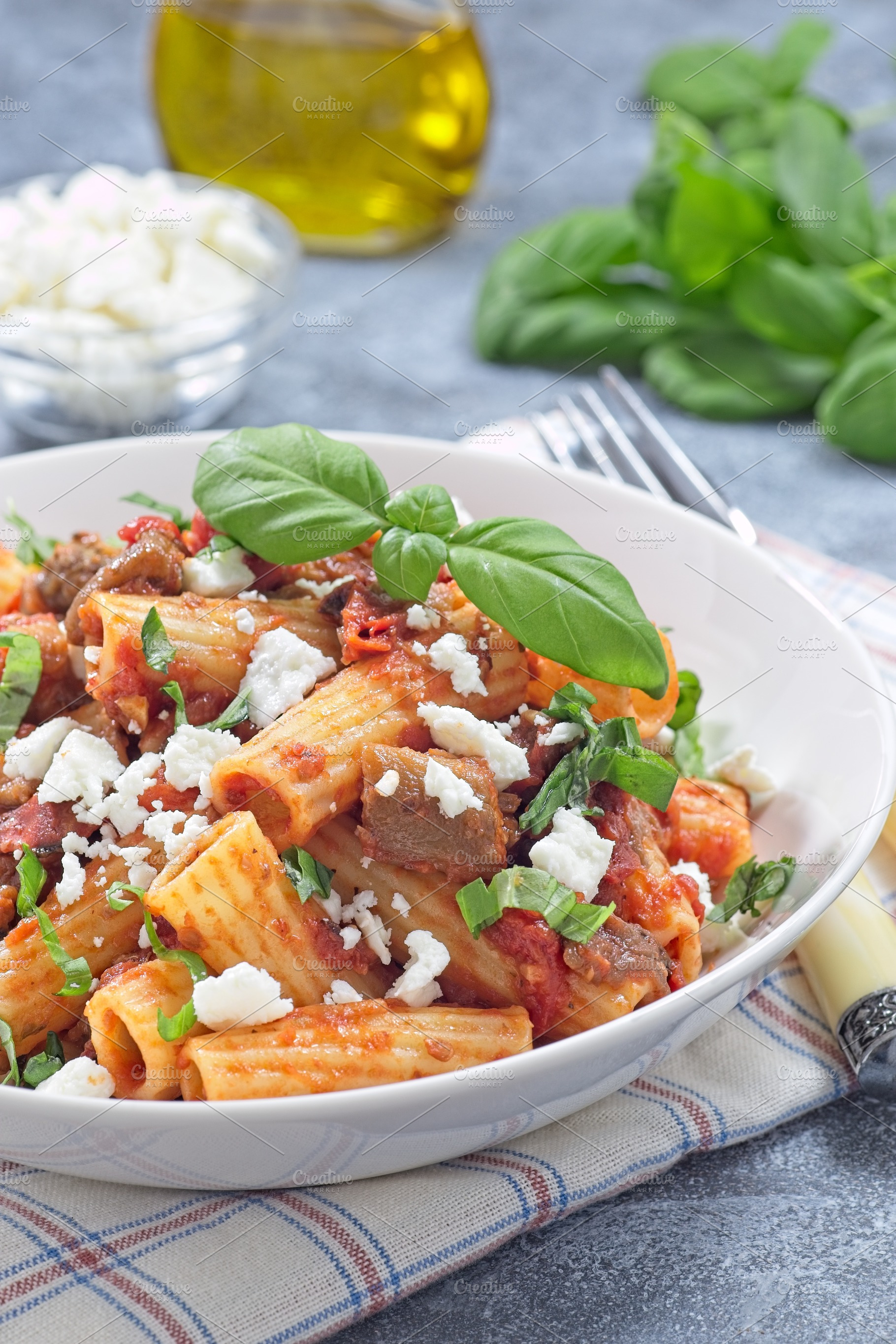 Rigatoni alla Norma pasta with eggplant and tomato, served with basil and ricot, a Food & Drink Photo by iuliia_n