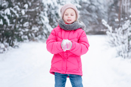 Little girl in a bright jacket plays in the winter forest, a Person Photo by Olena Rudo