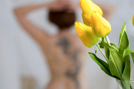 Yellow flowers in front of nude female model in a studio, a Beauty & Fashion Photo by Barcelona_dreams
