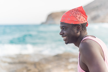 african male person happily enjoying the summer looking at ocean, a Holiday Photo by Iván Moreno STOCK PHOTO
