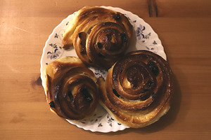 Three cinnamon rolls with raisins on a floral plate, a Food & Drink Photo by Textures & Backgrounds