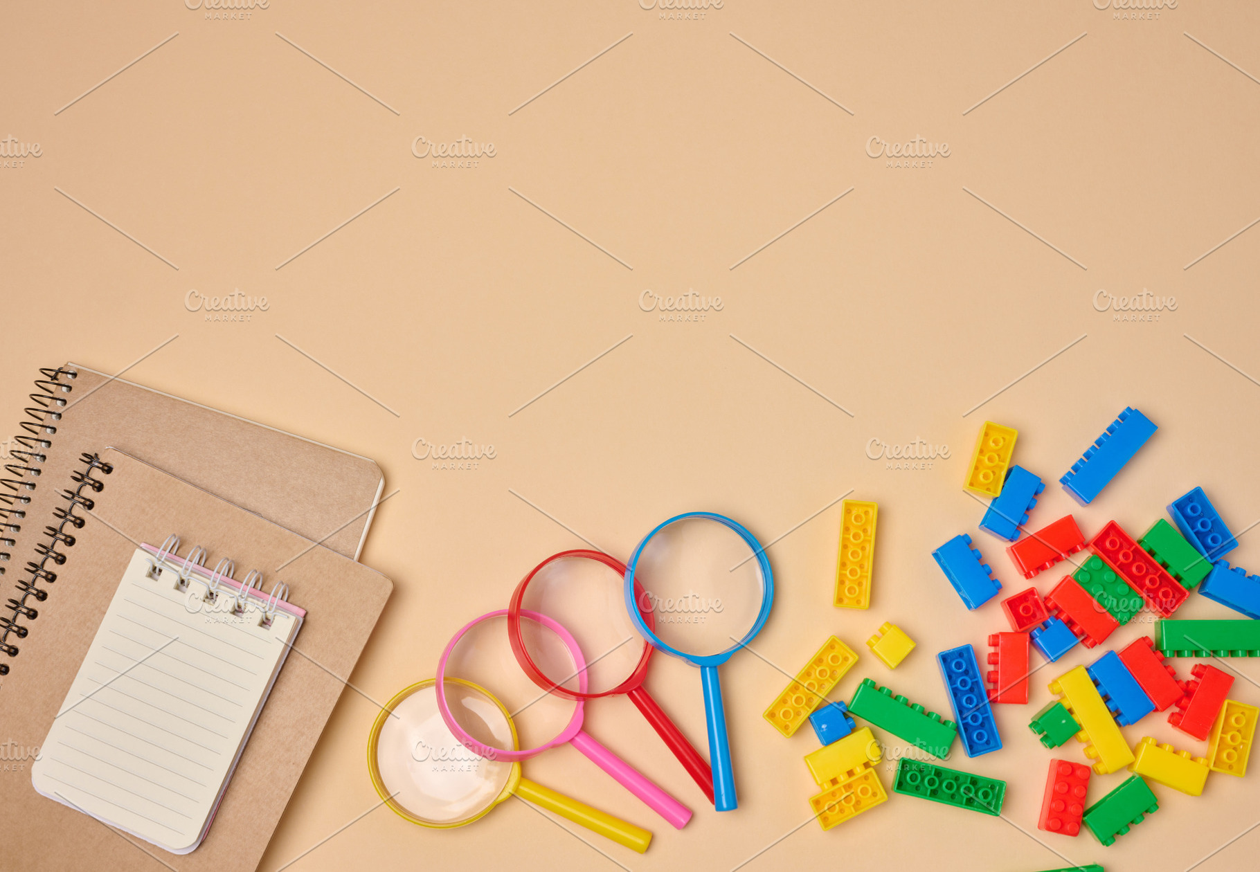 Flat lay of colorful plastic building blocks, magnifying glasses, a School & Education Photo by ndanko