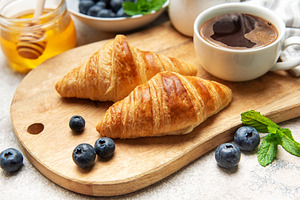 Delicious french croissants with coffee, honey and fresh blueber, a Food & Drink Photo by Olena Rudo