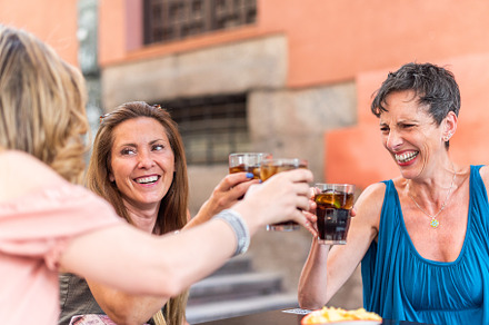 Adult woman with short hair in a cafe toasting with drinks with her friends, a Person Photo by Iván Moreno STOCK PHOTO