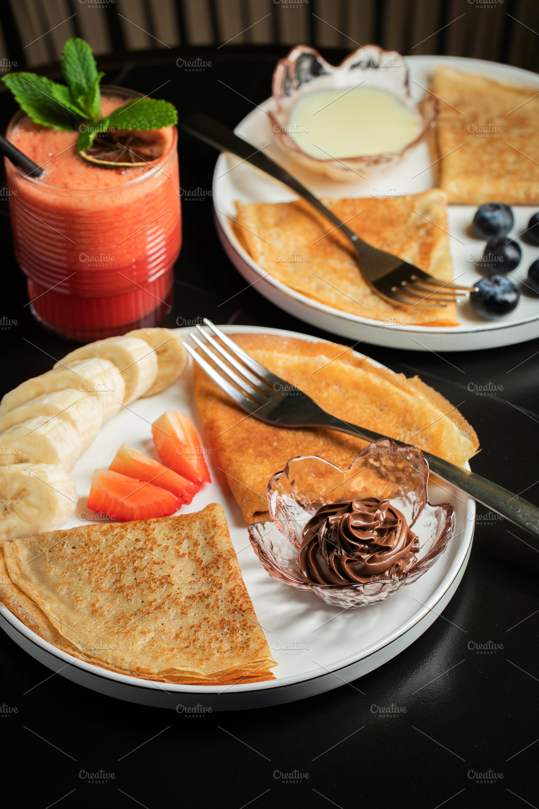 A plate of crepes filled with chocolate spread and topped with banana slices an, a Food & Drink Photo by Budarinphoto