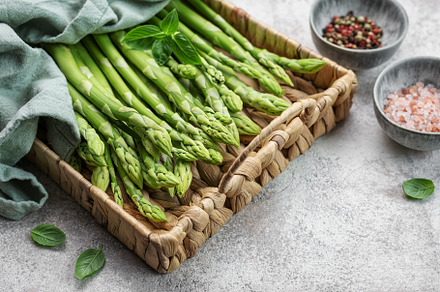 Bunch of raw asparagus stems with different spices, a Food & Drink Photo by Olena Rudo
