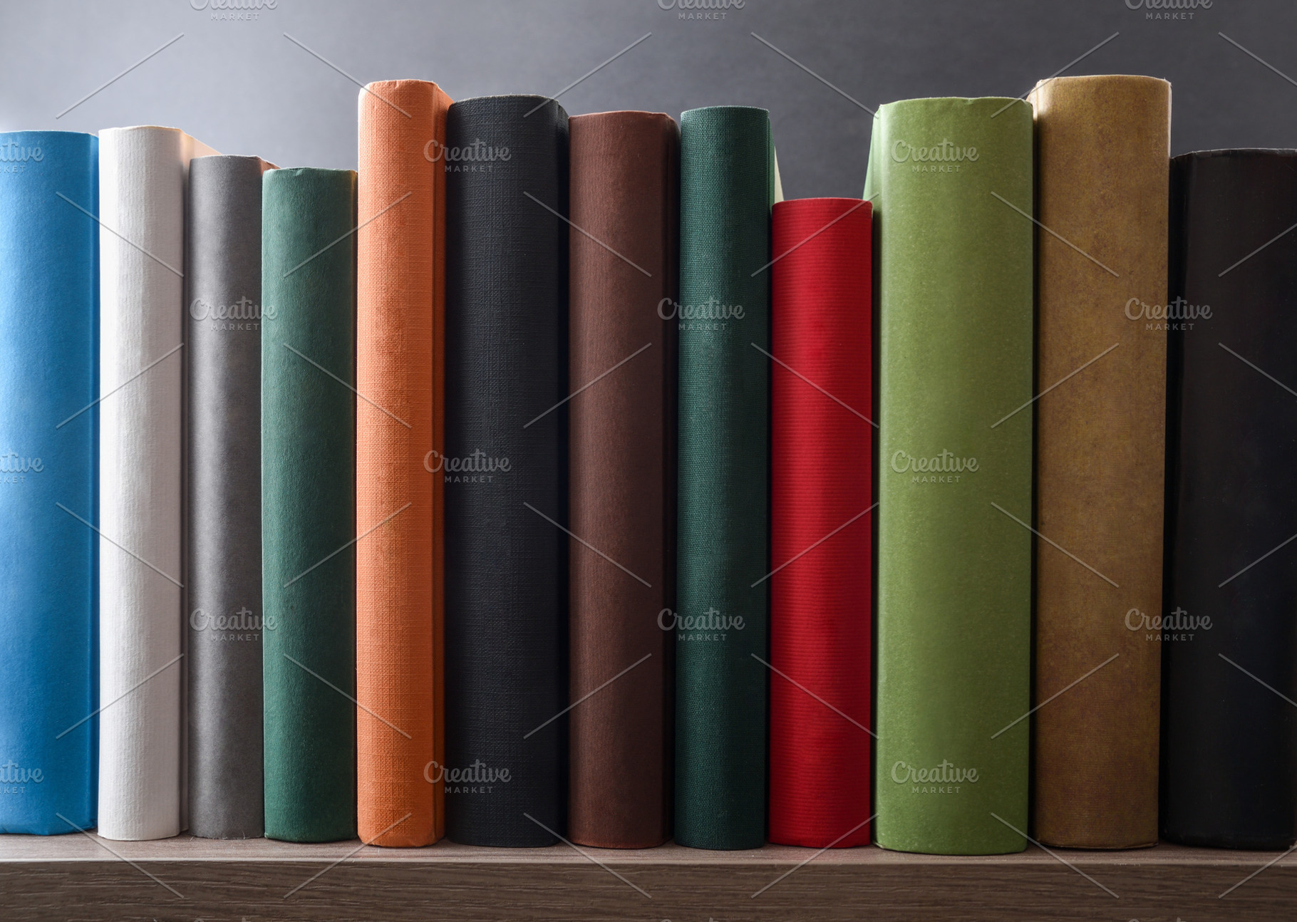 Row of books showing various colored spines on a shelf, a School & Education Photo by Davizro's Market