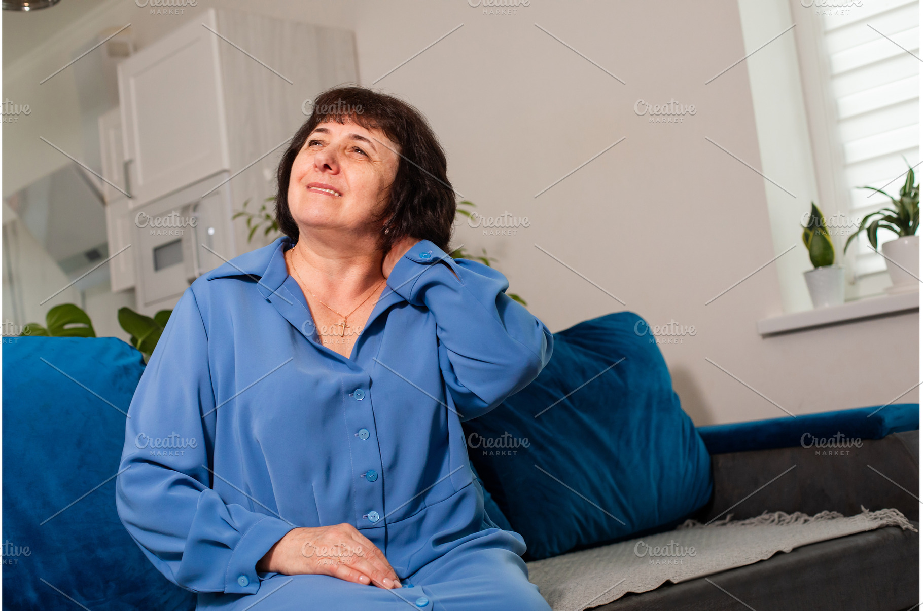 Older woman in blue shirt suffering, a Person Photo by oksix