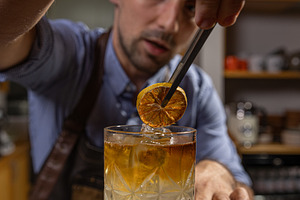 Bartender garnishing a cocktail, a Photo by Grafvision photography