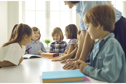 Kids together with teacher reading, a School & Education Photo by StudioRomantic