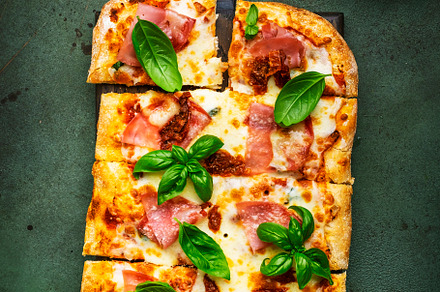 Hot Roman pizza with ham, pancetta, mozzarella cheese, sun dried
