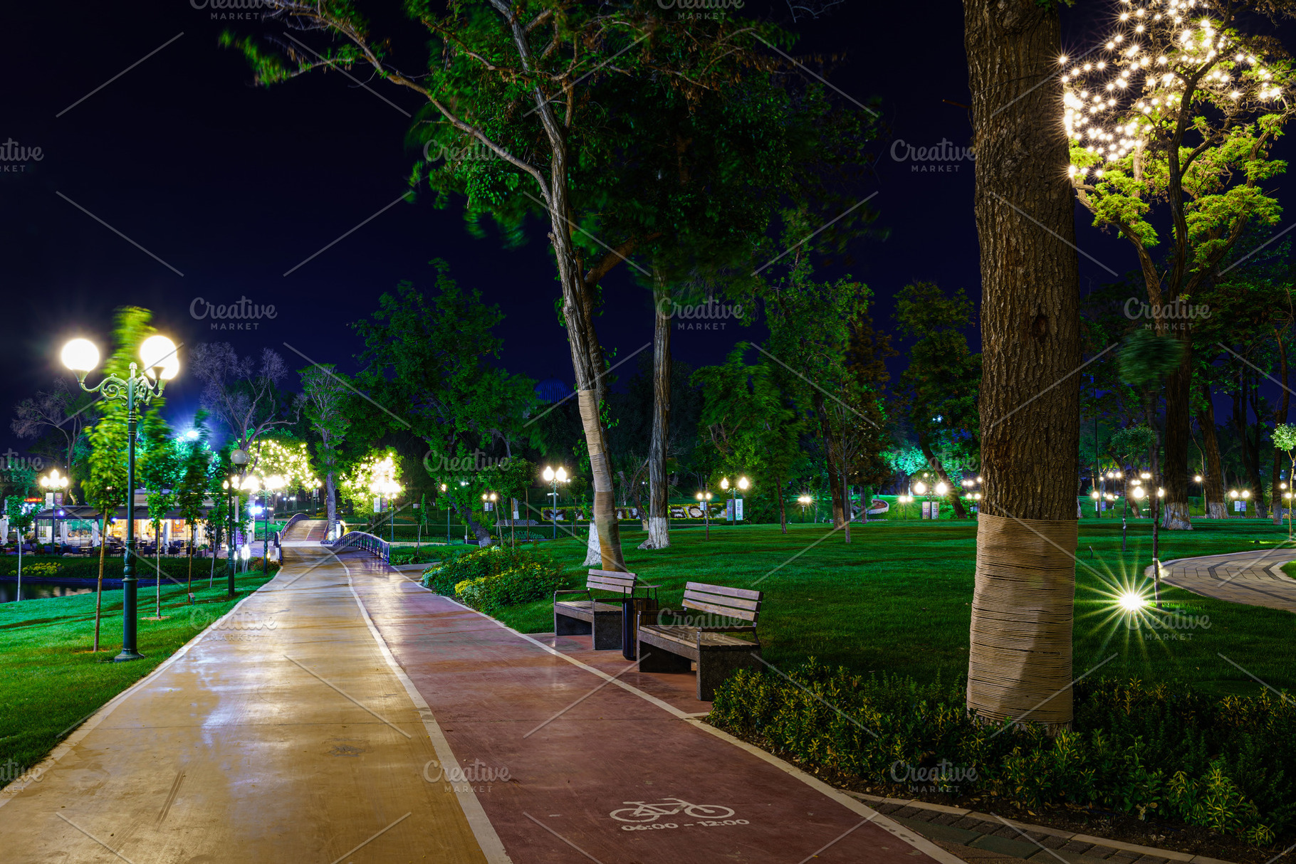 Illuminated park at night with a long path and green grass, feat, a Nature Photo by Eugene_Photo