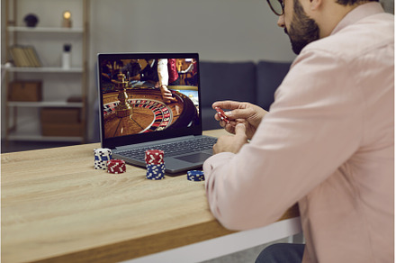 Gambler man sitting at laptop, a Person Photo by StudioRomantic