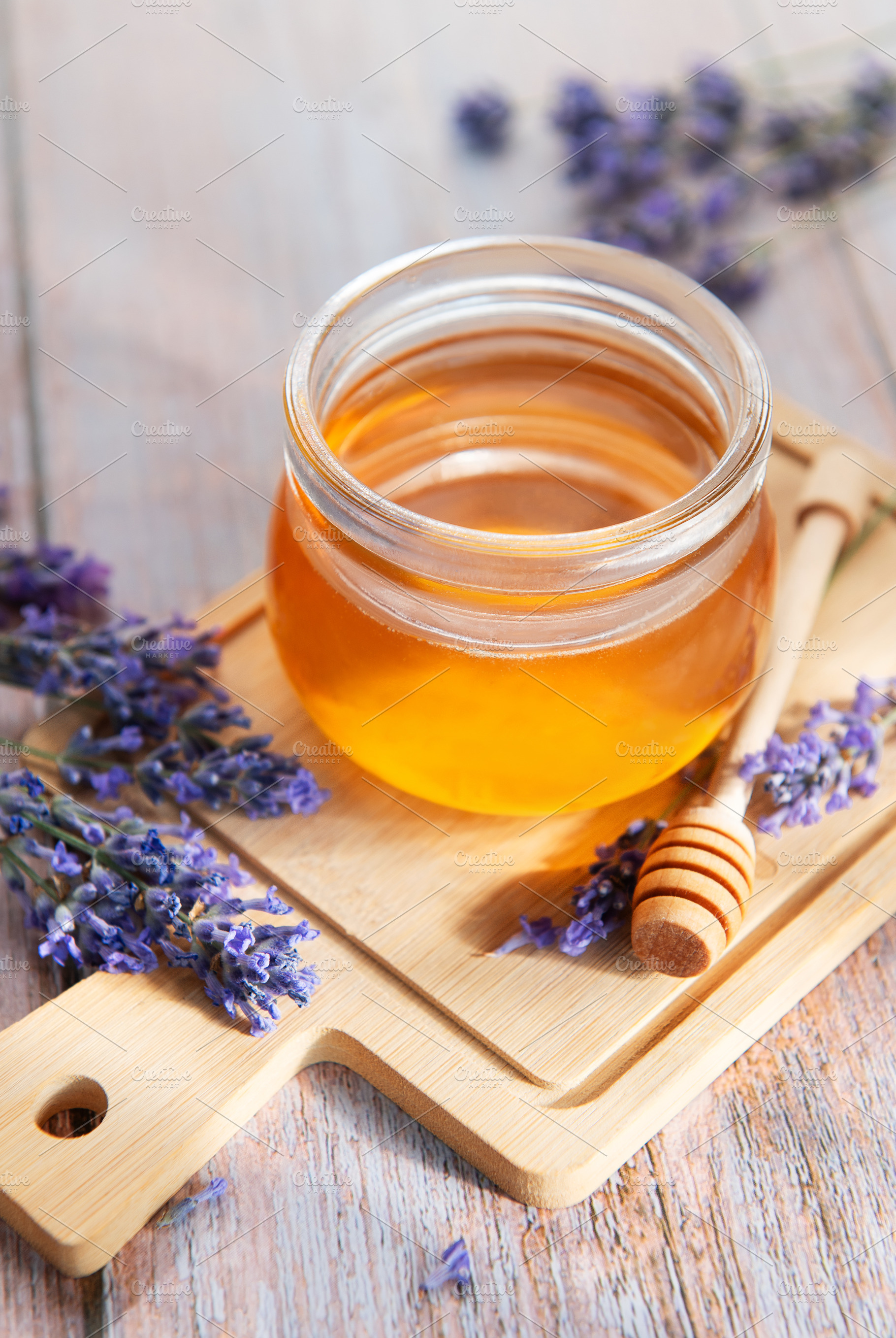 Honey jar with lavender flowers on wooden board, a Food & Drink Photo by Olena Rudo