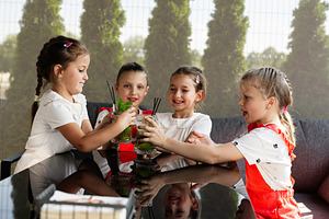 Four young friends enjoy refreshing drinks together at an outdoor gathering, a Photo by AS photostudio