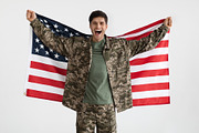 Cheerful military guy with flag of the US on white, a Photo by Prostock-Studio (Thumbnail 3 of 4)