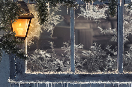 Beautiful winter window. Snow, icicles. Yellow lantern