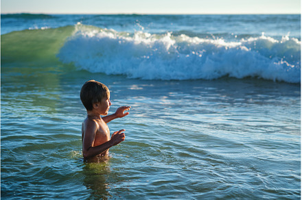 Boy having fun jumping in ocean sea, a Person Photo by f9photos