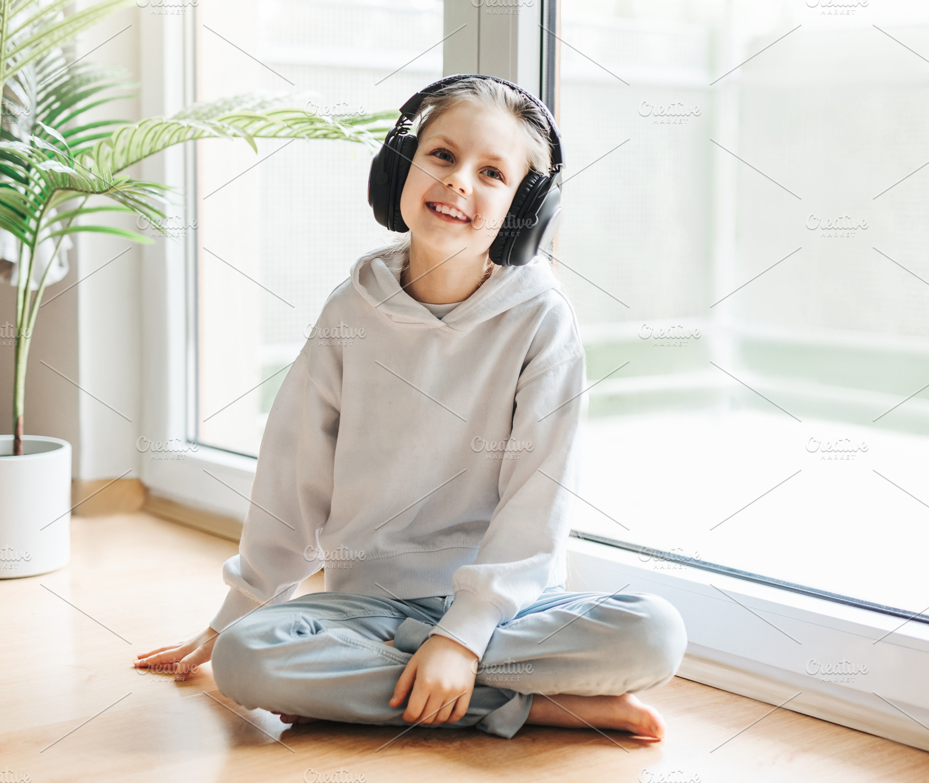 Cute little girl listening to music in headphones, a Person Photo by Olena Rudo