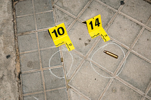 Evidence markers on pavement at crime scene with bullet casings