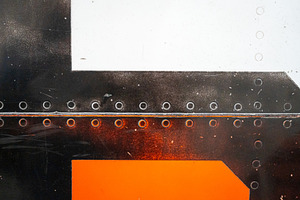Close-up of riveted orange and white aircraft fuselage with glos, a Wallpaper Photo by GoodGoods