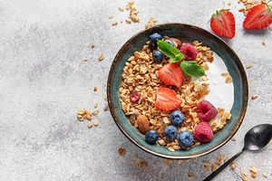 Granola bowl with yogurt, berries, and nuts for breakfast, a Food & Drink Photo by Olena Rudo