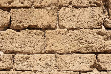 Texture of uneven stone brick wall in sunlight, a Holiday Photo by Iván Moreno STOCK PHOTO