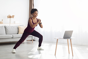 Happy black lady enjoying online fitness class