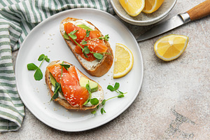 Salmon avocado toasts with microgreens and lemon, a Food & Drink Photo by Olena Rudo