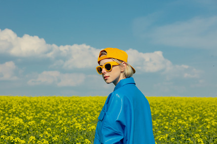 woman in blue shirt and yellow cap on blooming rapeseed field, a Person Photo by Masson Simon