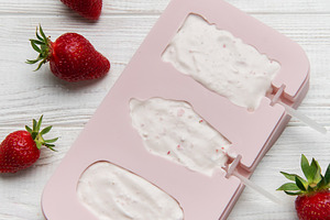 Homemade strawberry ice cream pops preparation on wooden backgro, a Food & Drink Photo by Olena Rudo