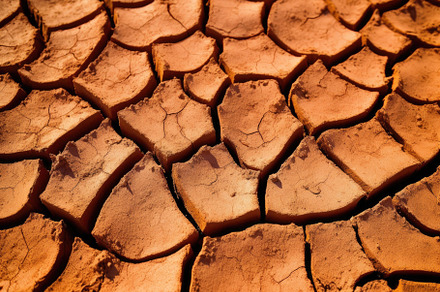 Dry cracked land in a desert, in the style of terracotta, enviro, a Nature Photo by designvectx