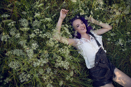portrait of a teenage girl with purple hair and an earring in her nose lying in, a Person Photo by SaulichPhoto