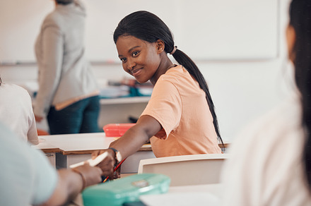Girl, teenager or passing note in classroom for secret gossip, news or prom date question on high school or college campus. Smile, happy or students with paper message in education or learning lesson, a Photo by Peopleimages.com