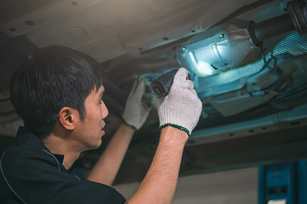 Asian male mechanical hold and shining flashlight to examine car, an Industrial Photo by Ministocker