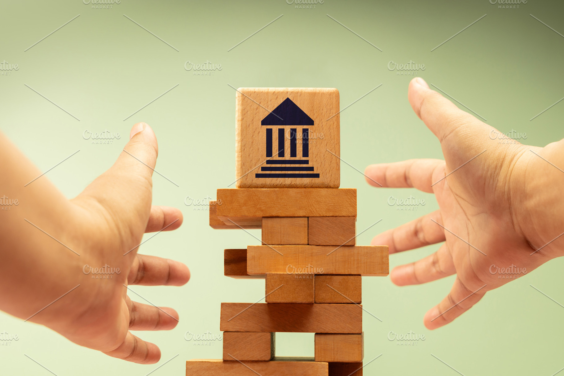 Hands reaching toward unstable wooden blocks with government ban, a Photo by salmon.black