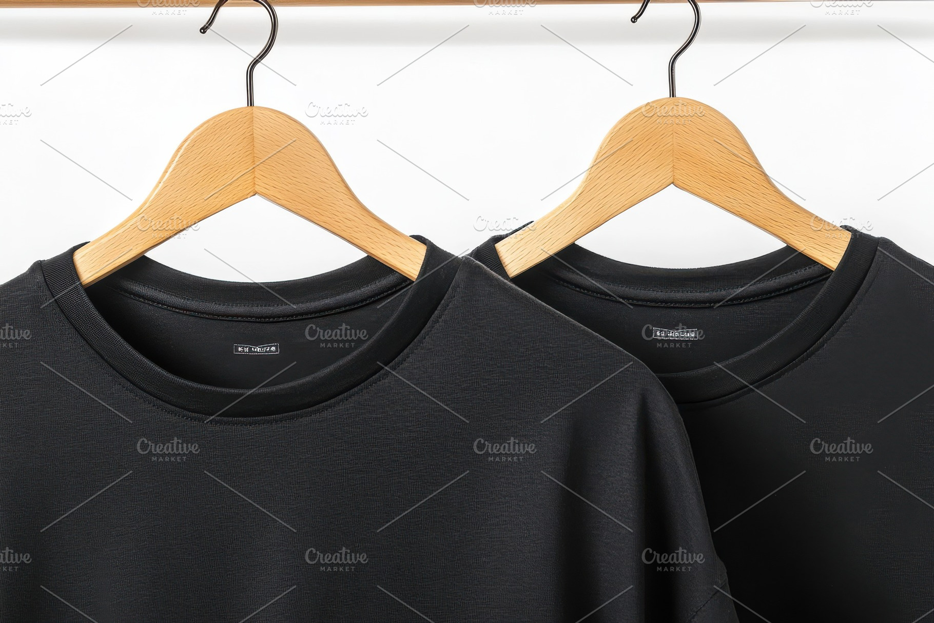 Two black t-shirts on wooden hangers, a Background Photo by Pixeness