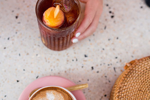 A hand with a cold drink and coffee