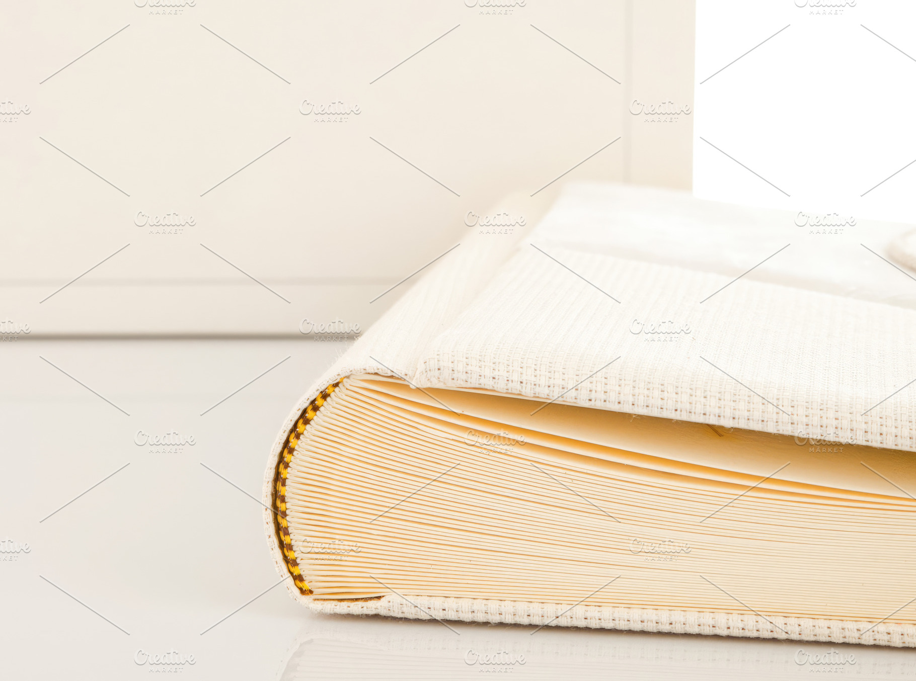 Wedding photo album with box and white cover with golden seam binding resting o, an Abstract Photo by Antonio Gravante Market