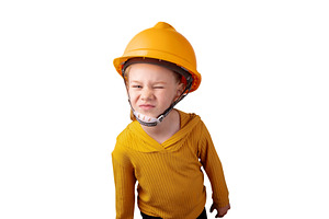 Smiling child wearing a yellow construction helmet and sweater,, a Person Photo by Ales Munt