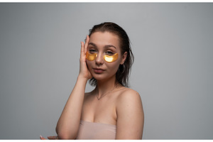 Young woman applying golden eye, a Health & Medical Photo by volodymyrshtun13795