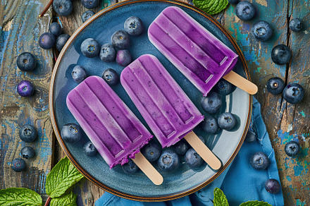 Ice cream popsicles with organic blueberries on wooden background, a Food & Drink Photo by AlyaAnd
