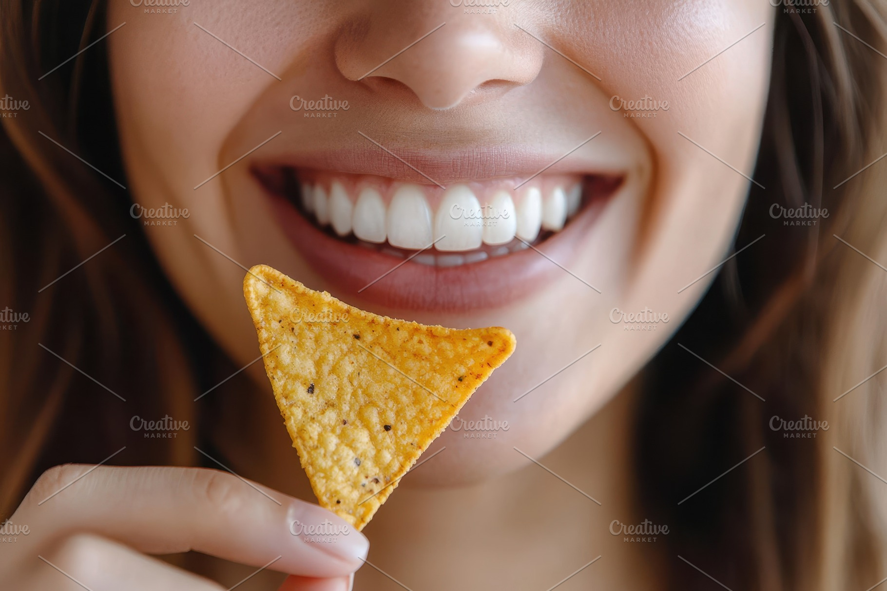 Woman enjoying a savory nacho chip, a Photo by Pavel_design