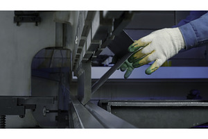 Close up of worker pressing metal at