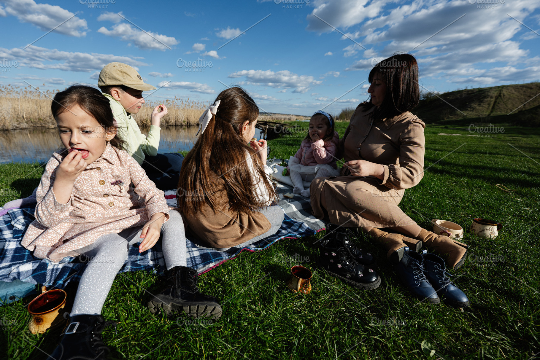 Family picnic by the lake with mother and children enjoying a sunny spring afte, a Person Photo by AS photostudio