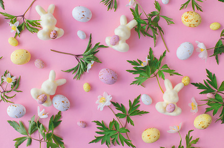 Colorful Easter chocolate eggs, bunnies and spring flowers flat, a Holiday Photo by Sonjachni
