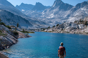 Hiker on rock by alpine lake, a Nature Photo by AlyaAnd